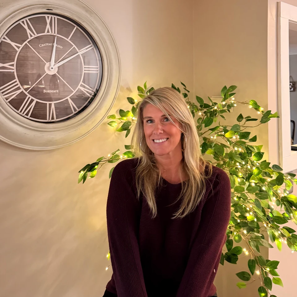 Kristin LeBlanc smiling in a warm, plant-filled room
